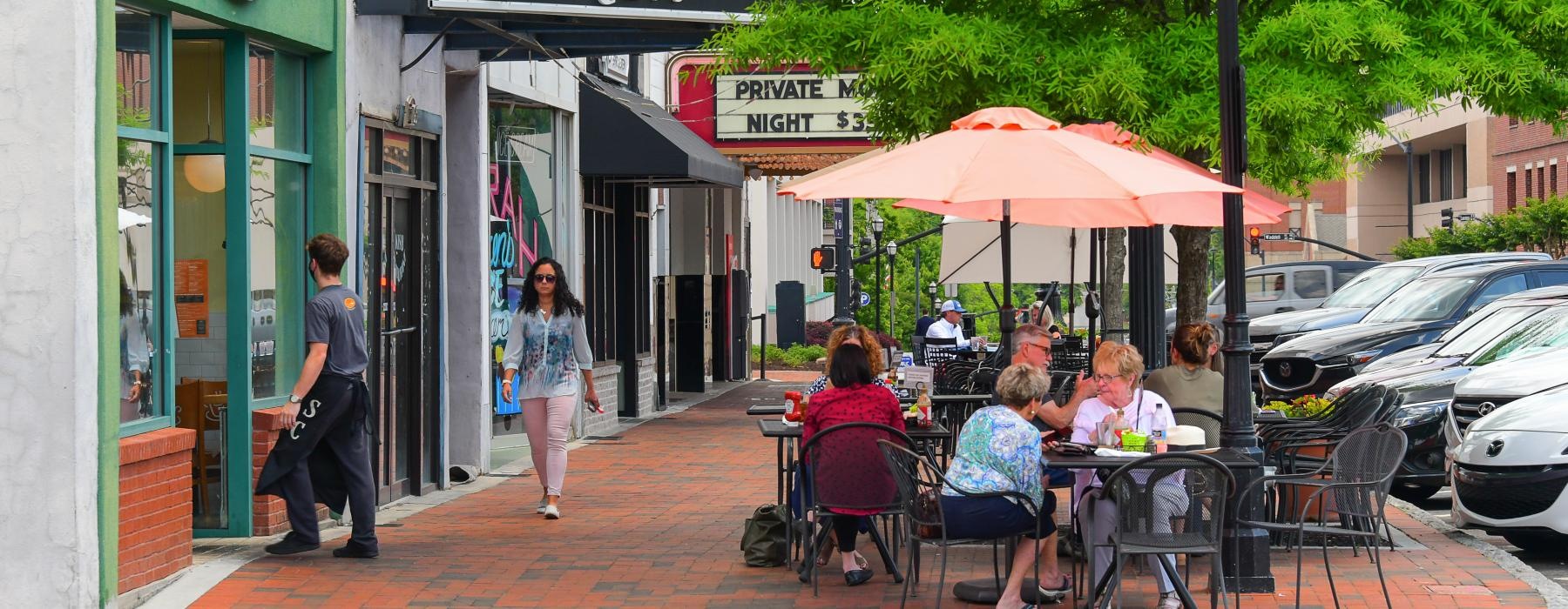 people sitting at tables outside a restaurant