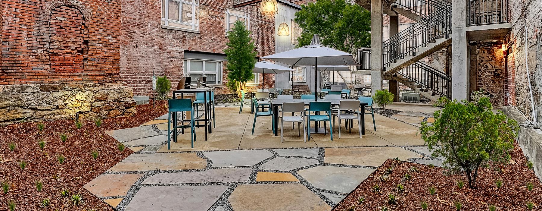 a patio with tables and chairs outside